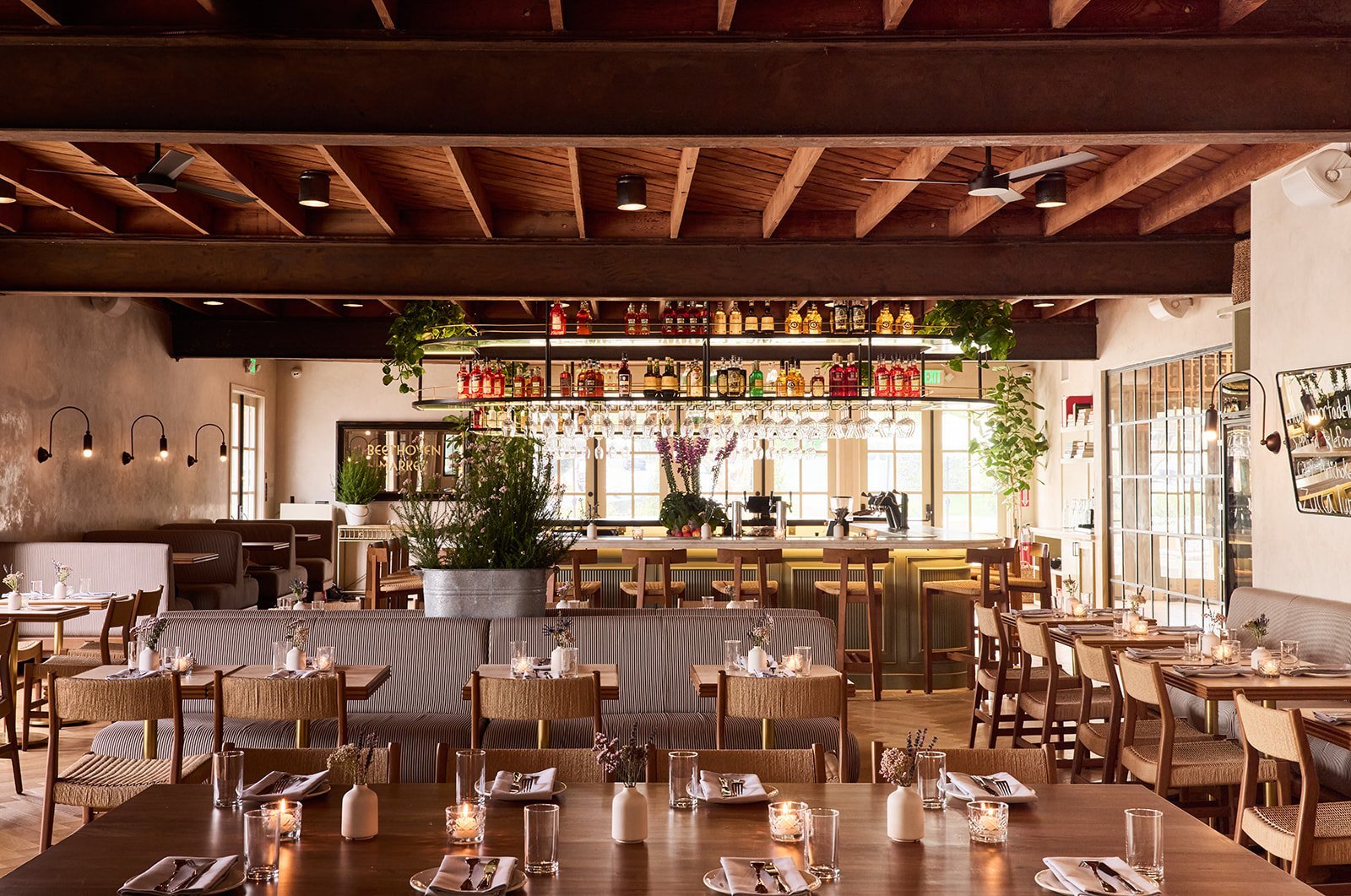 Dining room of a restaurant set for service, seen from the bar